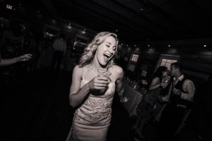 A black and white photo captures a joyful moment during a dimly lit reception.