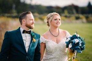 An elegant wedding portrait featuring a couple in formal attire against a natural backdrop.