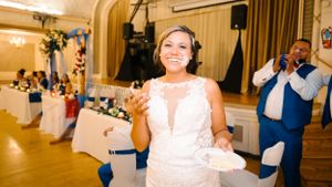 Bride dancing and celebrating at her wedding reception in an elegant ballroom setting.