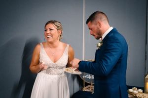 A joyful couple shares laughter during their wedding cake cutting ceremony.