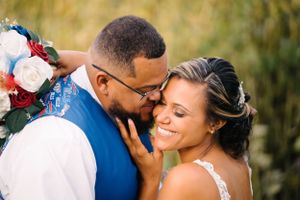 Close-up portrait of newlyweds sharing gentle embrace outdoors.