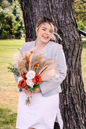 A joyful wedding photo showcasing a beautiful dried flower bouquet with pampas grass and roses.