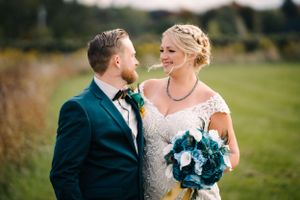 A loving moment between newlyweds captured in an outdoor setting with natural light.