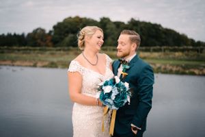 Happy couple shares candid moment during lakeside wedding photoshoot.