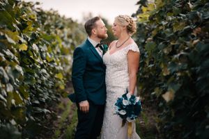A tender moment between newlyweds captured in a lush vineyard setting.
