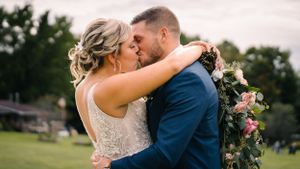 Intimate moment between couple during outdoor wedding photoshoot at sunset.