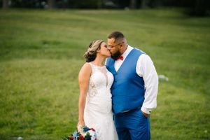 Intimate portrait of couple in wedding attire sharing romantic moment outdoors.