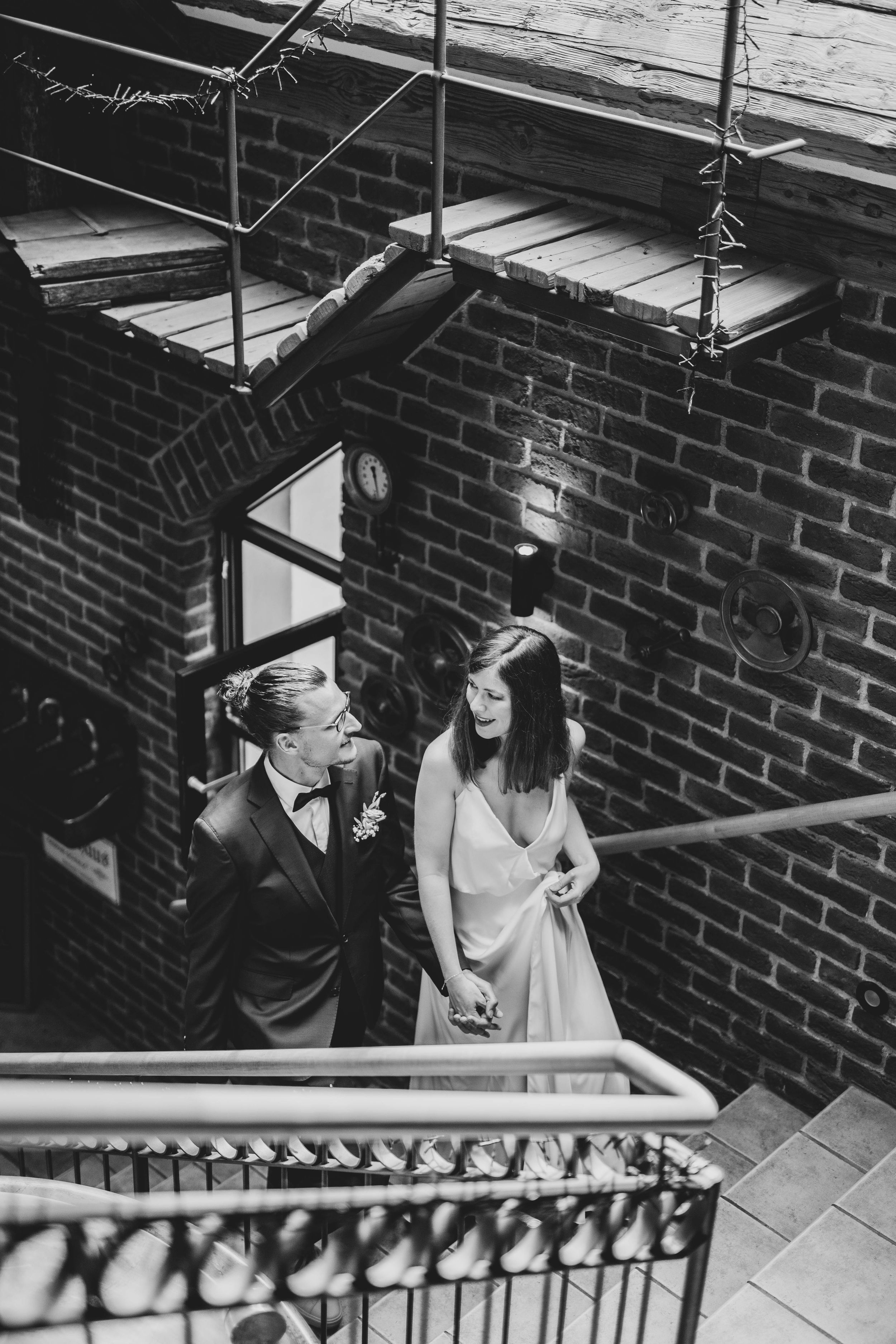 Black and white photo of a couple sharing a romantic moment on brick stairs.