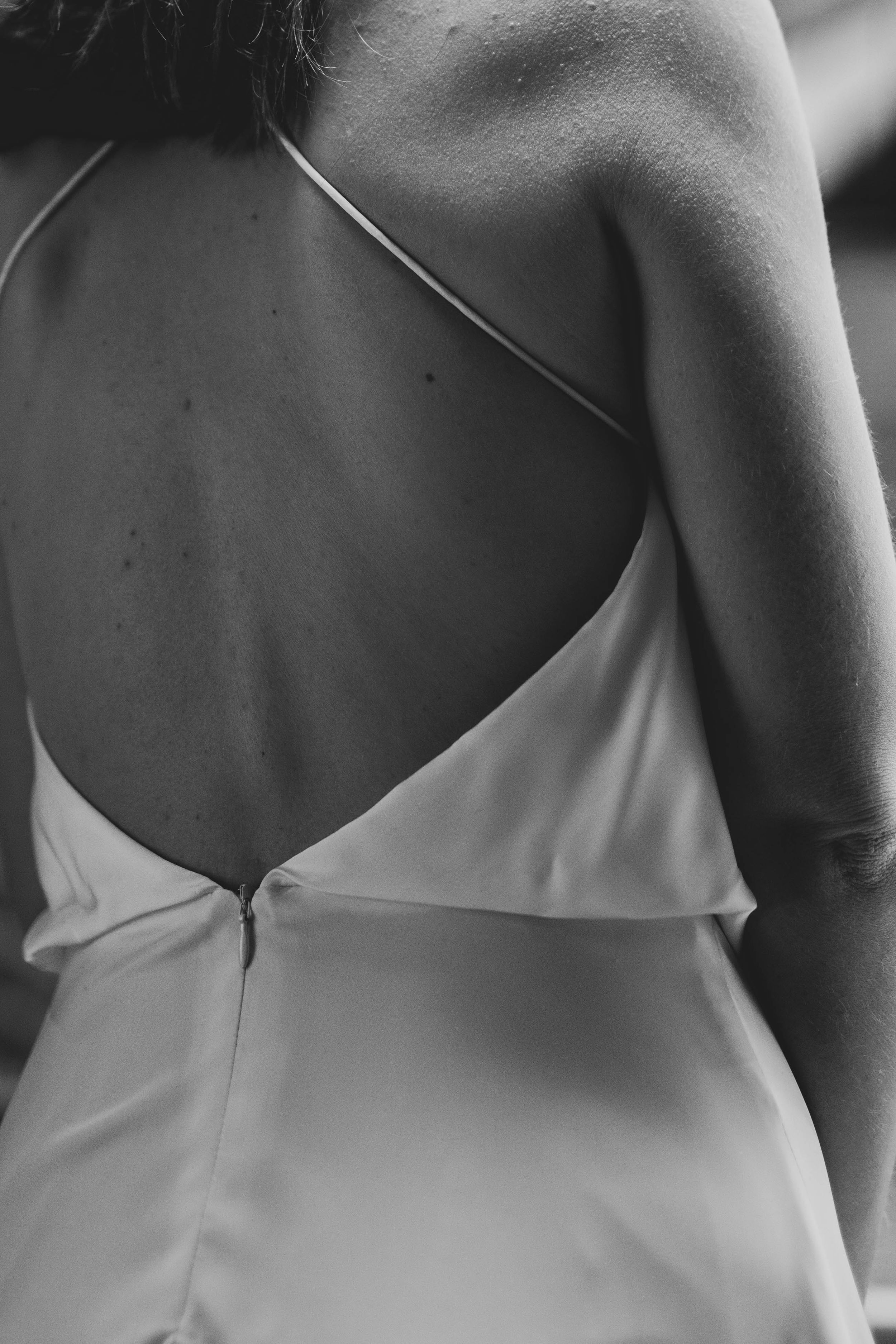 Close-up black and white detail of a backless wedding dress.