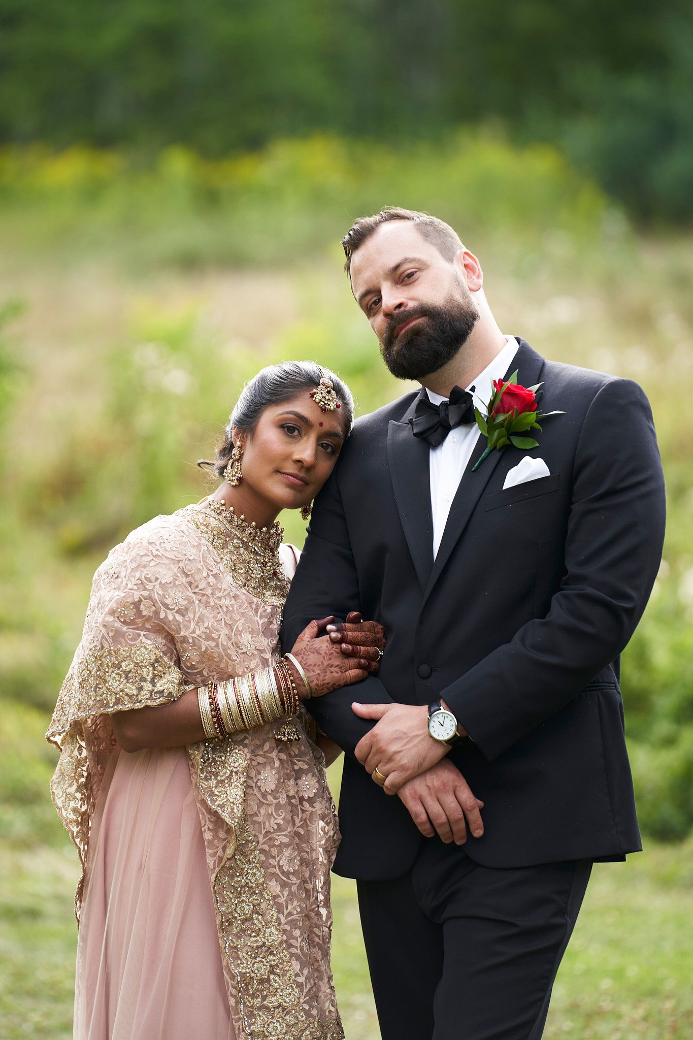 A couple in traditional wedding attire pose together outdoors during their special day at the Guelph Arboretum.