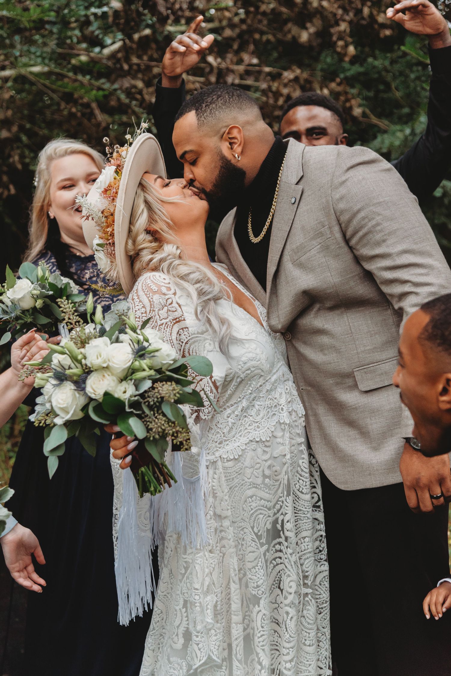 A joyous wedding celebration with guests cheering as the newlyweds share a kiss.