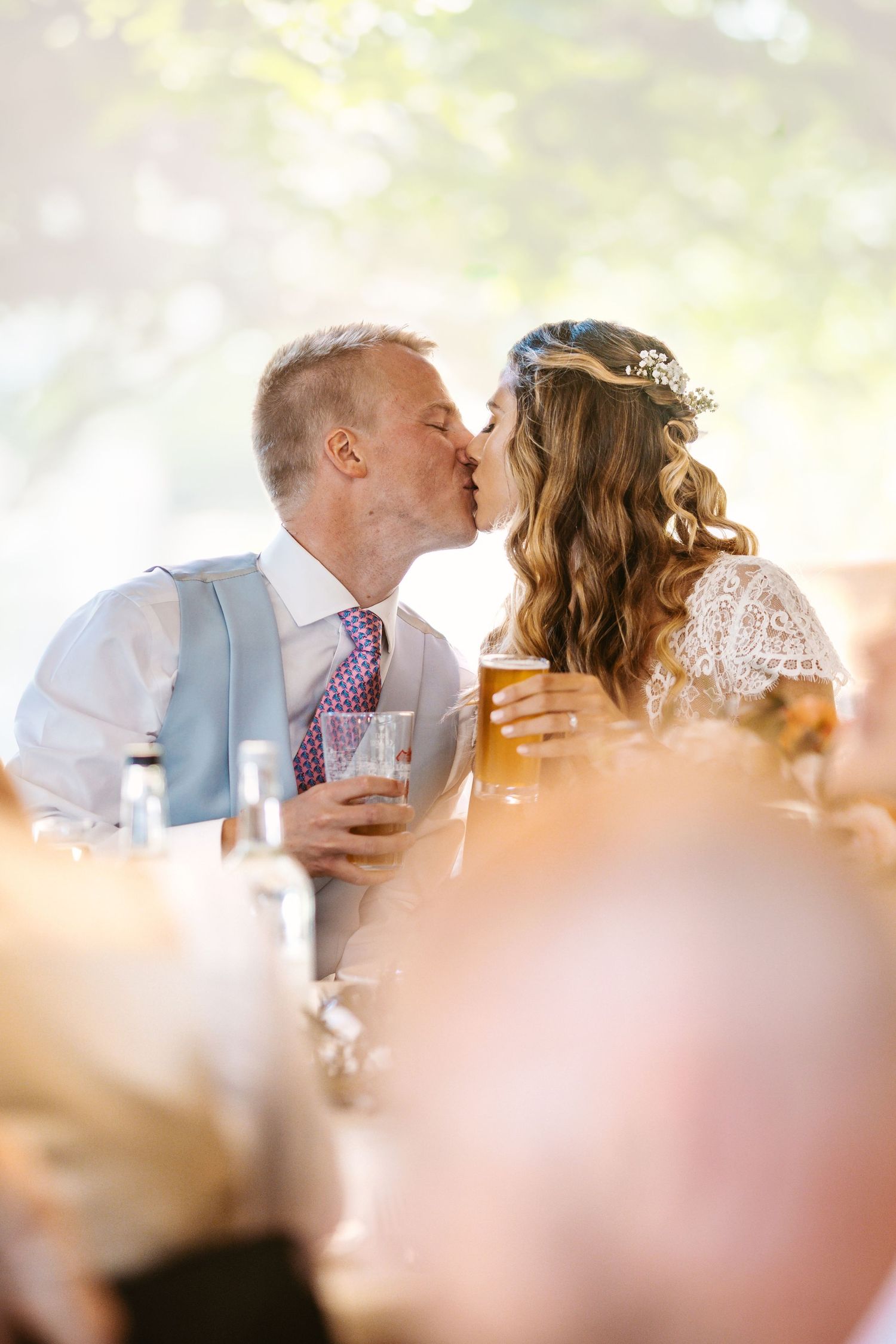 Newlyweds share an intimate moment during their reception with soft golden lighting.