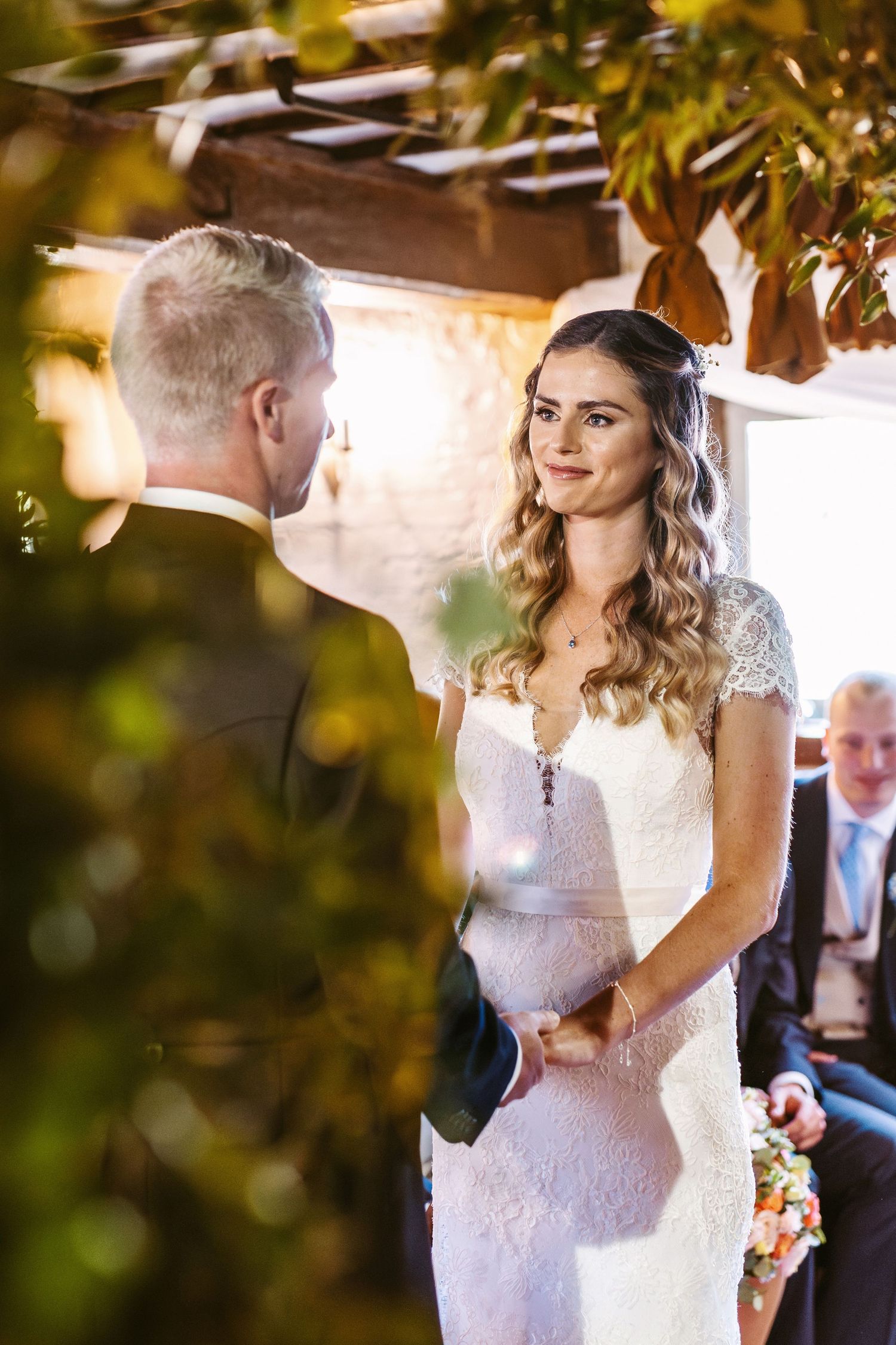 Intimate wedding ceremony moment under golden sunlit foliage.