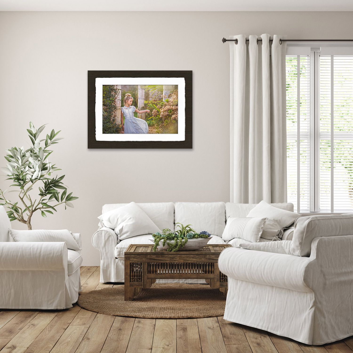 Bright living room with white slipcovered furniture, framed artwork and natural decor.