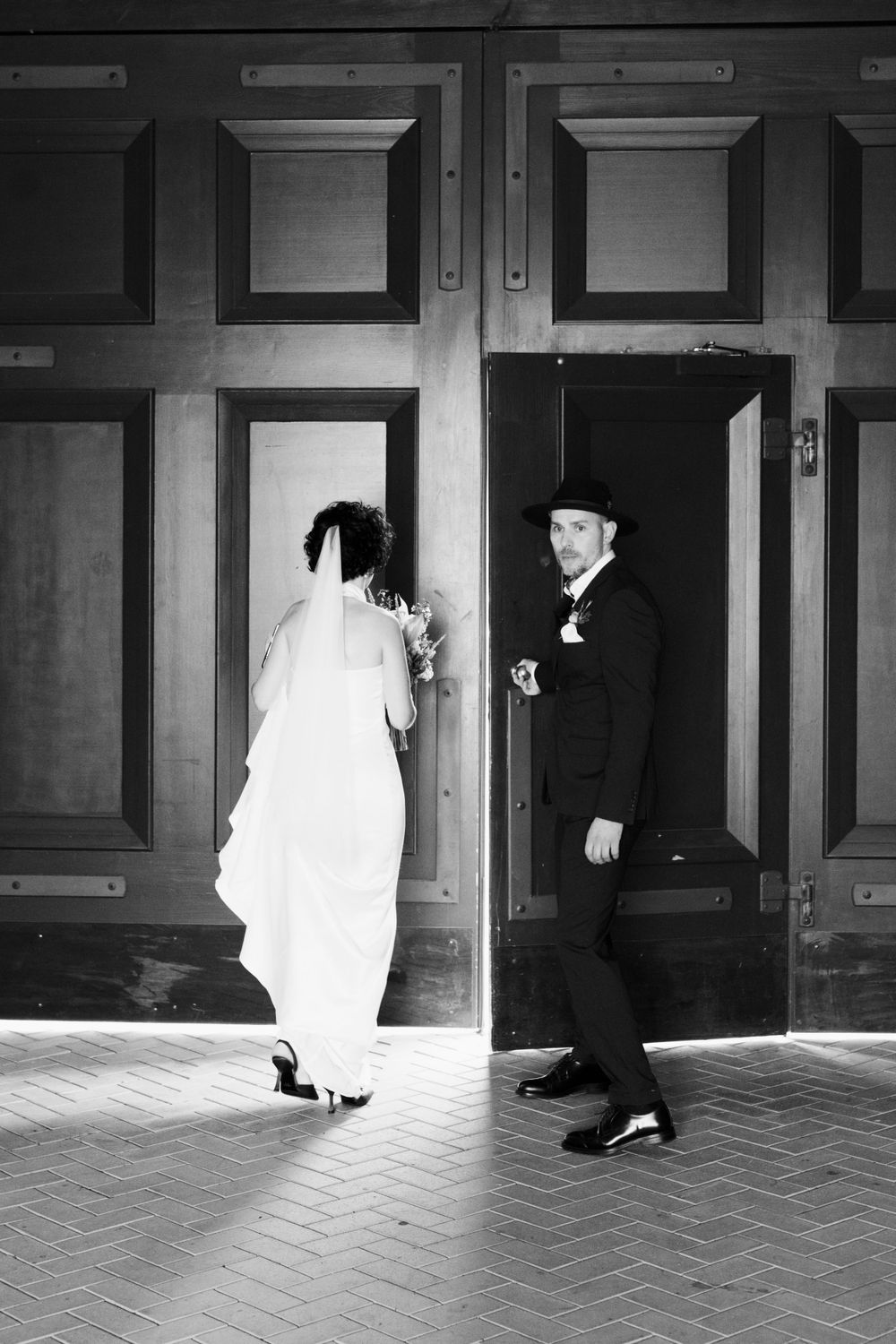A bride and a groom against the door.