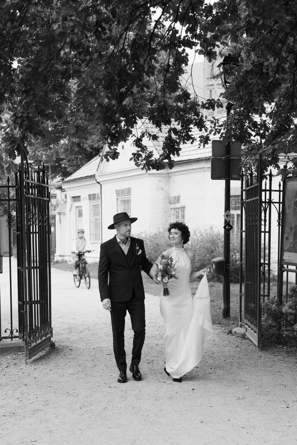 A bride and a groom are walking in the park.
