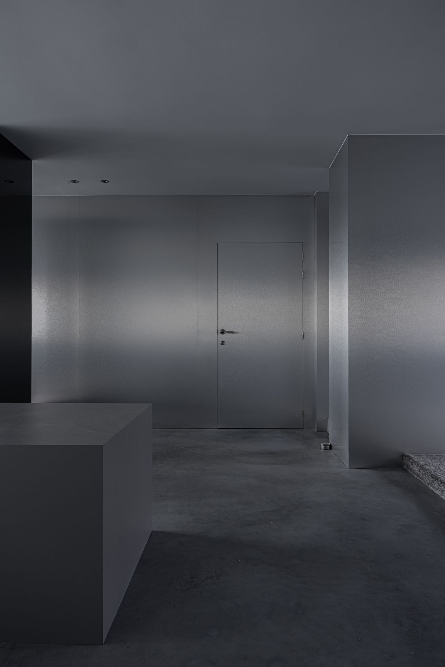 Modern minimalist interior space with gray concrete floors and white walls.