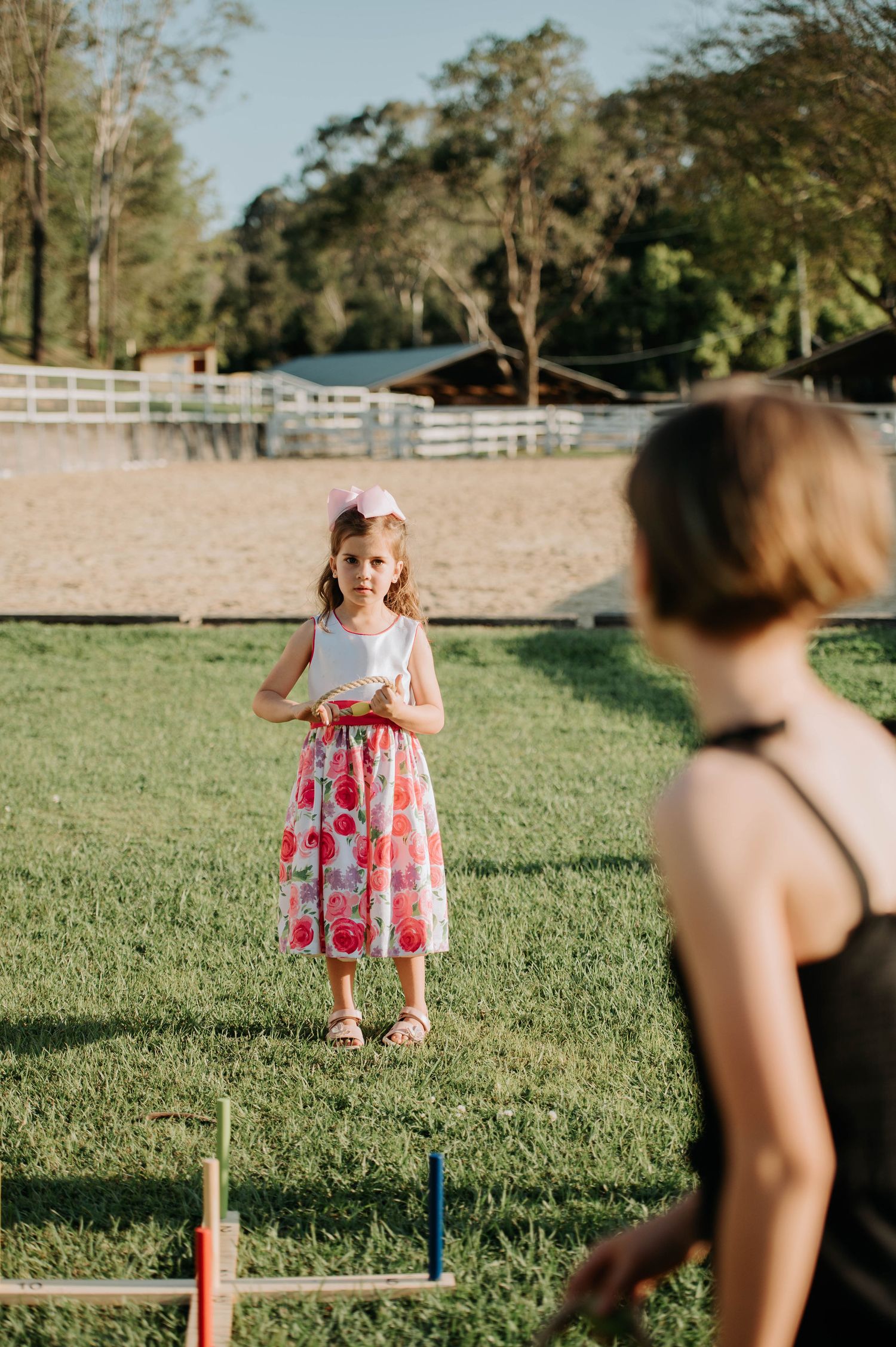 A child playing outdoor games on a grassy field with yard equipment.