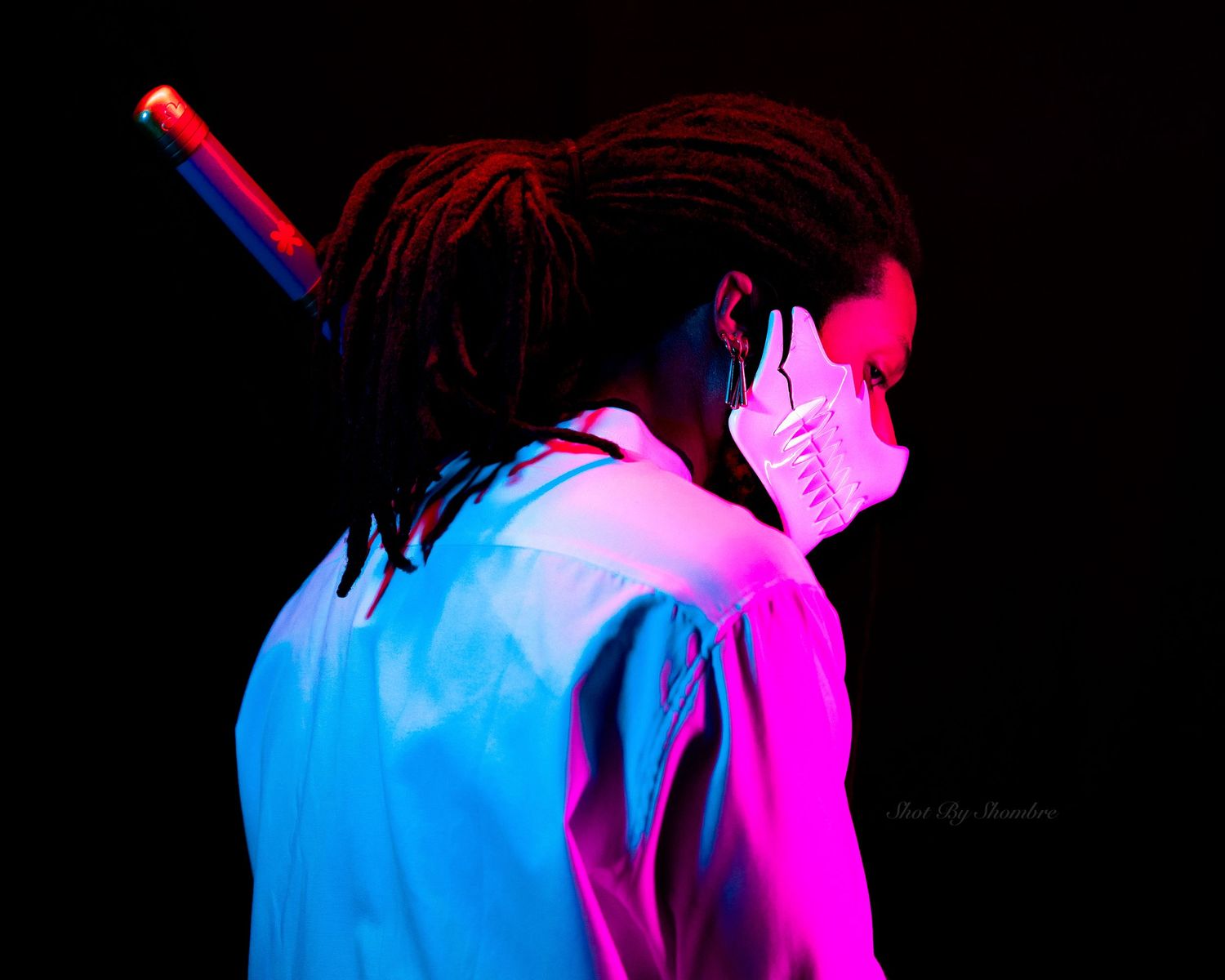 Artistic portrait with neon pink and blue lighting effects creating a dramatic silhouette.