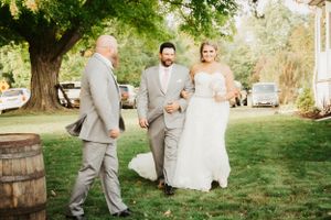 Wedding celebration in garden setting with rustic wine barrel decor.