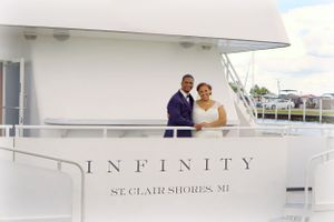 Couple standing on deck of yacht named Infinity in St. Clair Shores.