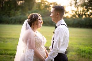 Romantic wedding couple shares intimate moment in sunlit garden during golden hour.