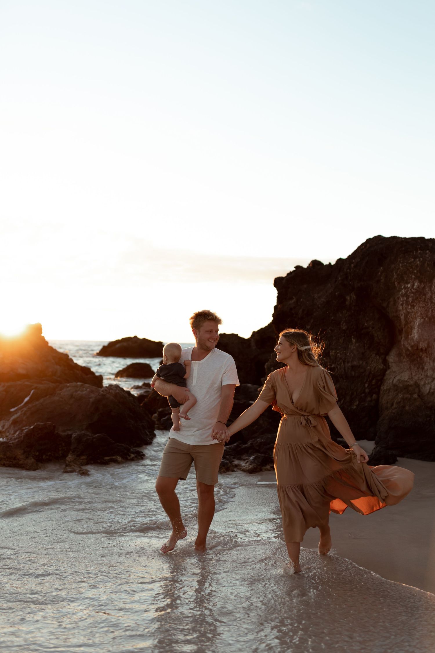 Beach engagement celebration couple on the rocks by the water in Hawaii Big Island