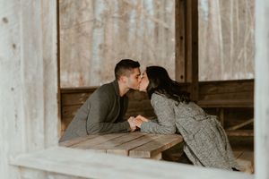 Intimate couple sharing romantic moment in rustic wooden cabin setting.