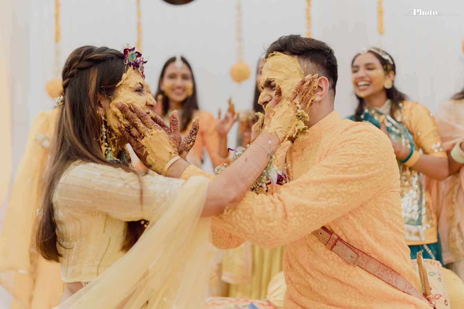 Wedding party members in coordinated yellow attire dance and celebrate together.