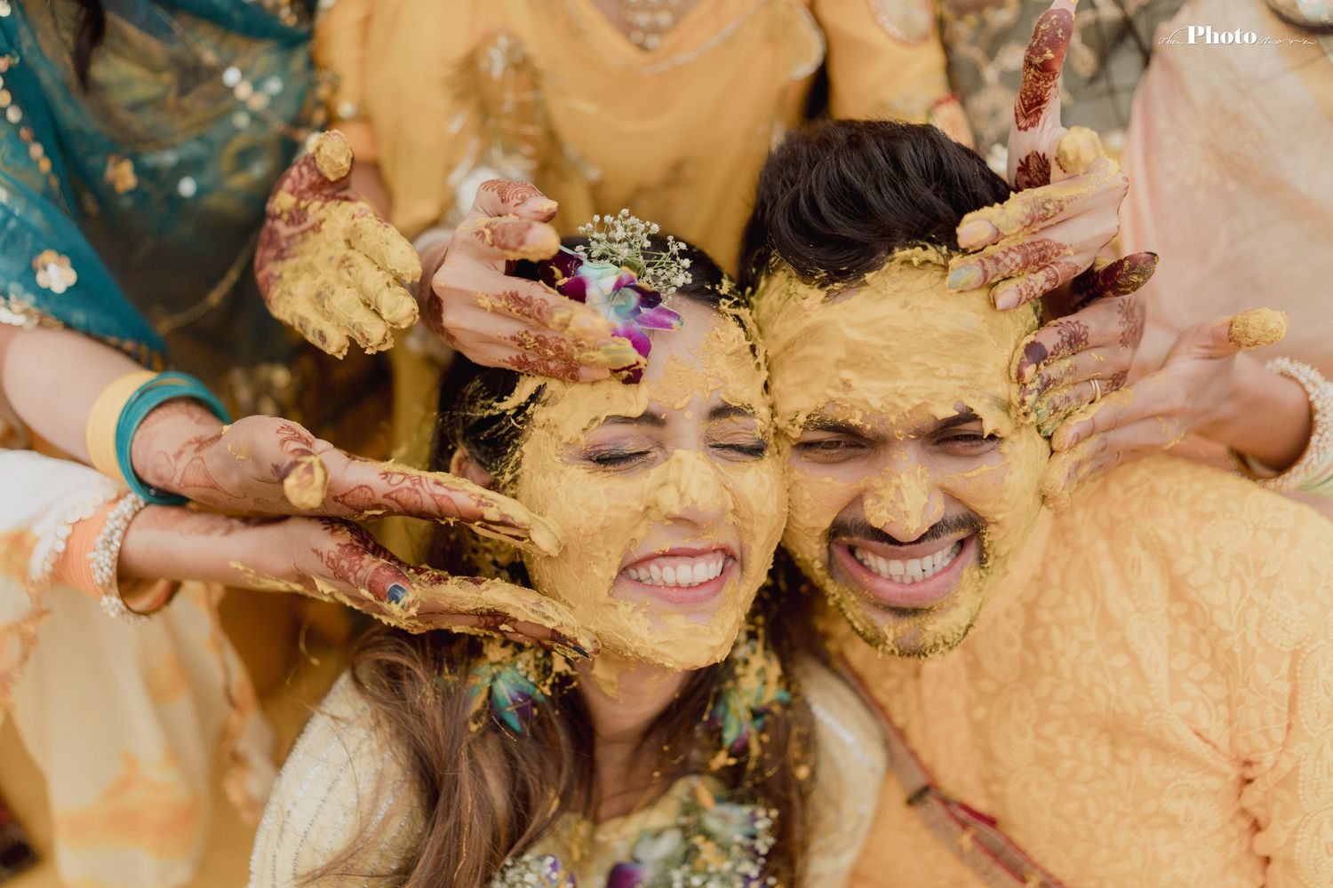 Wedding guests playfully smashing cake on each other's faces during a joyous celebration.