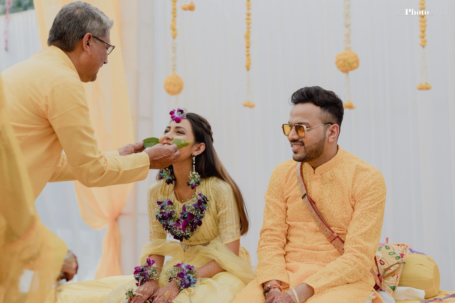 Traditional haldi ceremony in progress with yellow turmeric application during Indian wedding ritual.