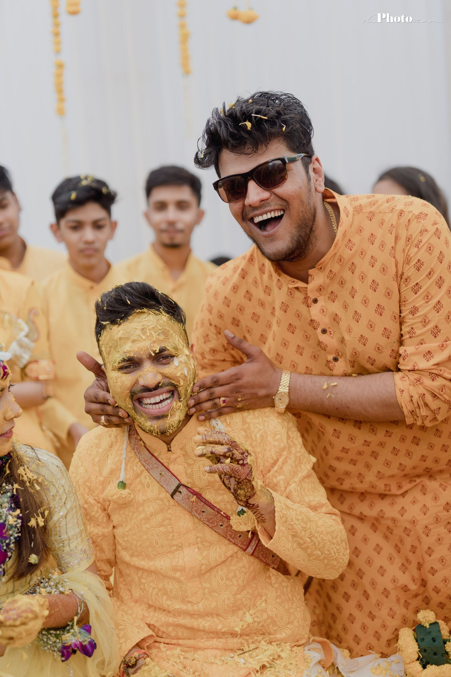 Joyful celebration with yellow turmeric during traditional haldi ceremony.