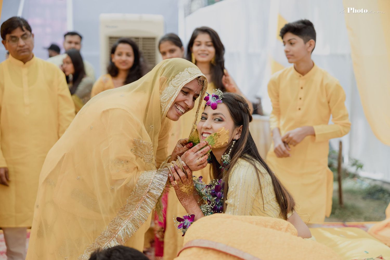 Traditional wedding ceremony with guests in yellow attire participating in festive celebrations.