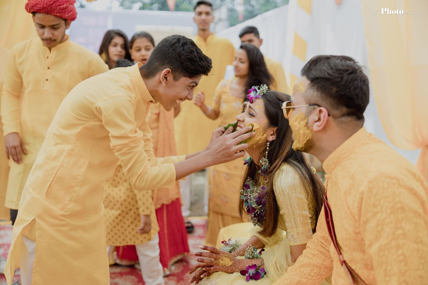Traditional Indian wedding guests in yellow attire participate in ceremonial celebrations.