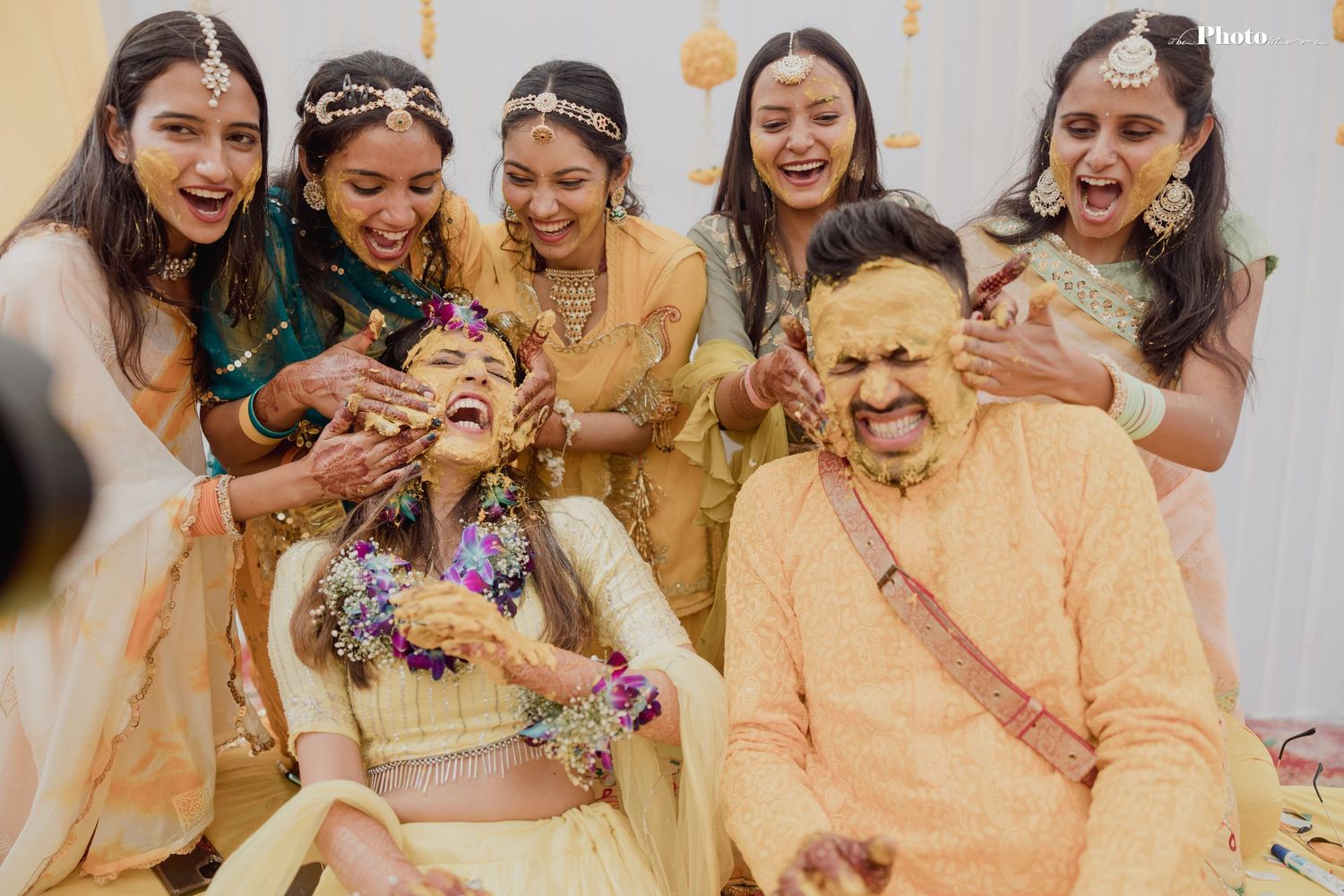Wedding party members in coordinated yellow attire share joyful moments during celebrations.