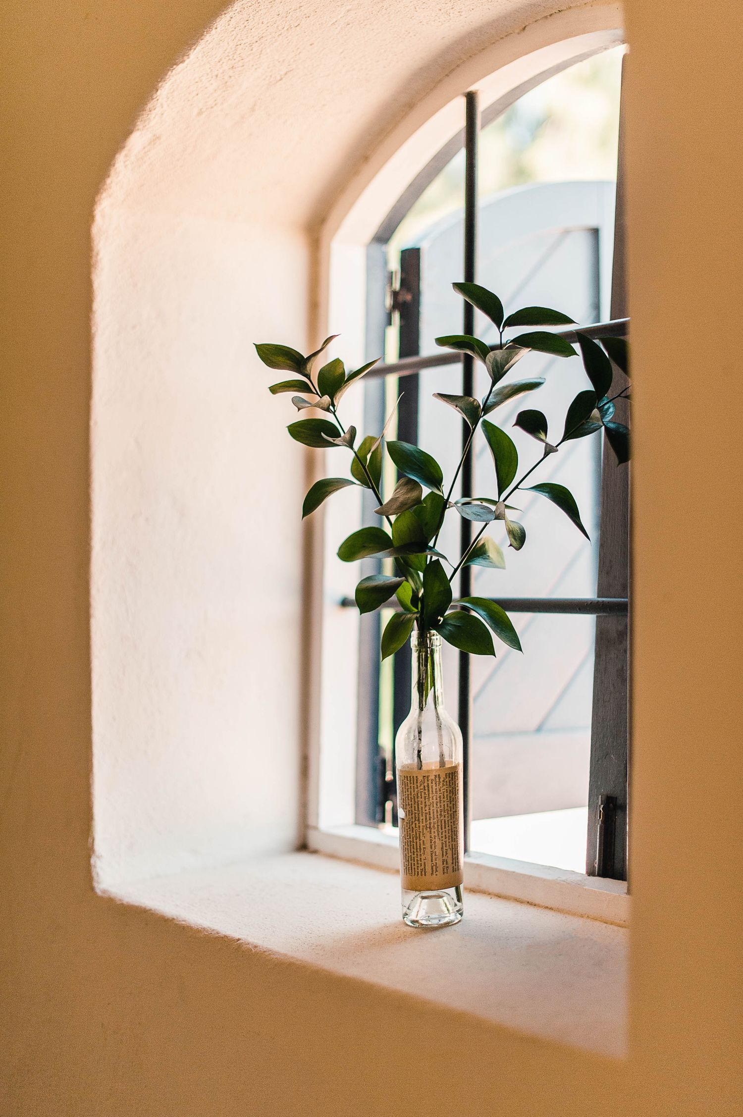 eucalyptus leaves in a vase on the windowsill of the small historic chapel at this destination wedding ceremony.