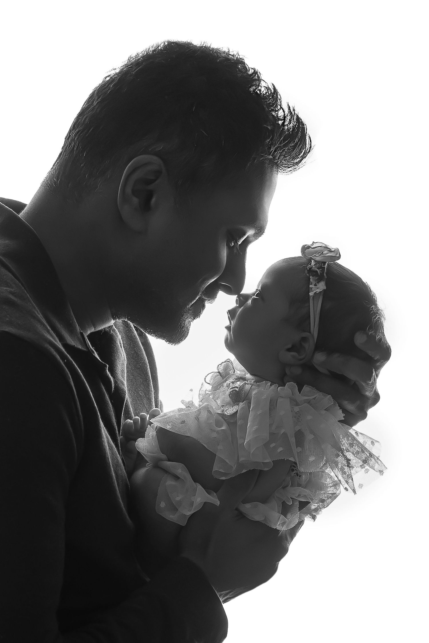 Tender black and white silhouette of a father holding his baby close, highlighting deep parental love.