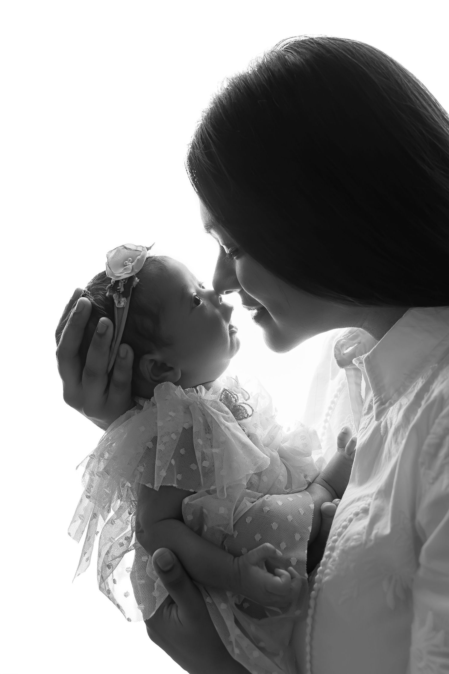 Artistic black and white silhouette of a mother cradling her baby, symbolizing love and connection.