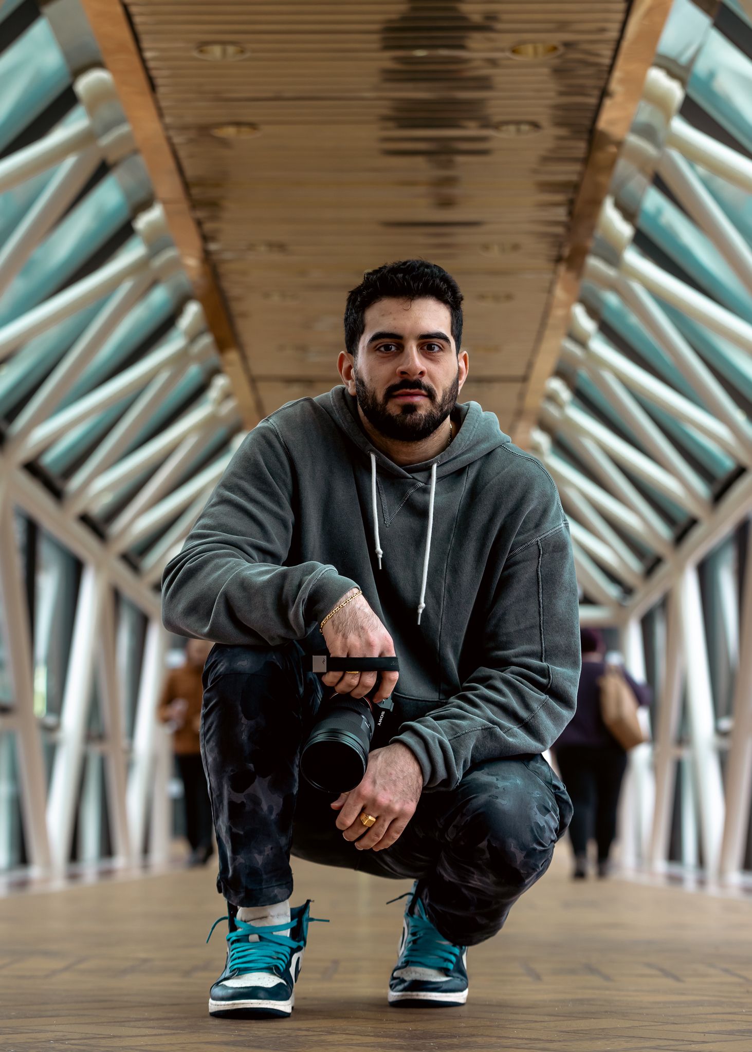 Architectural fashion shoot under geometric ceiling with person in sporty urban wear.