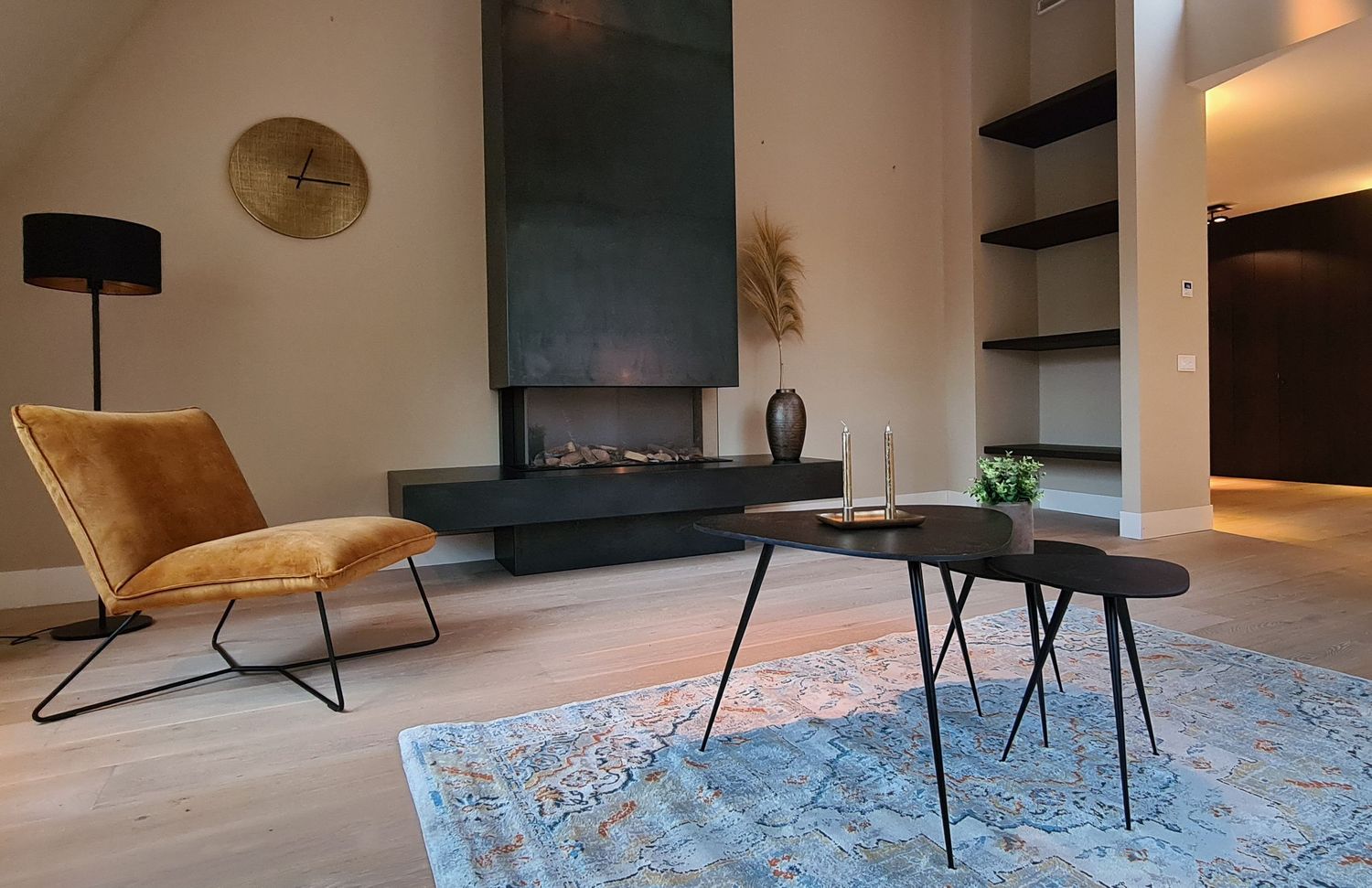 Modern fireplace in a room with ochre yellow chair, vintage rug and black coffee table set