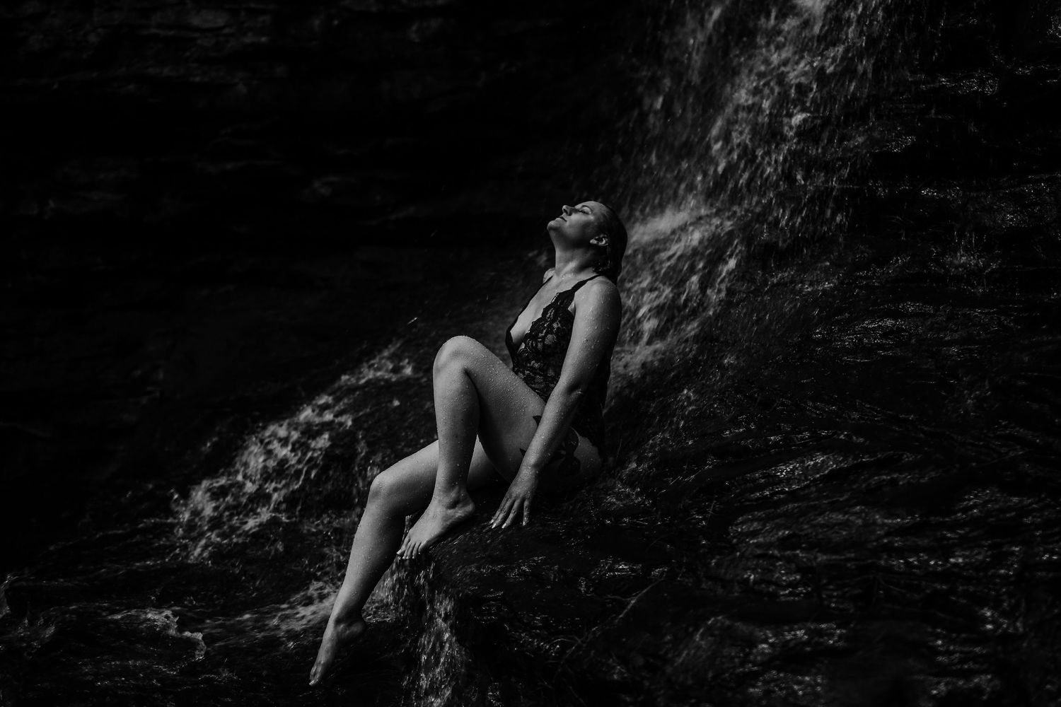Dramatic black and white photo capturing movement in water with artistic lighting.