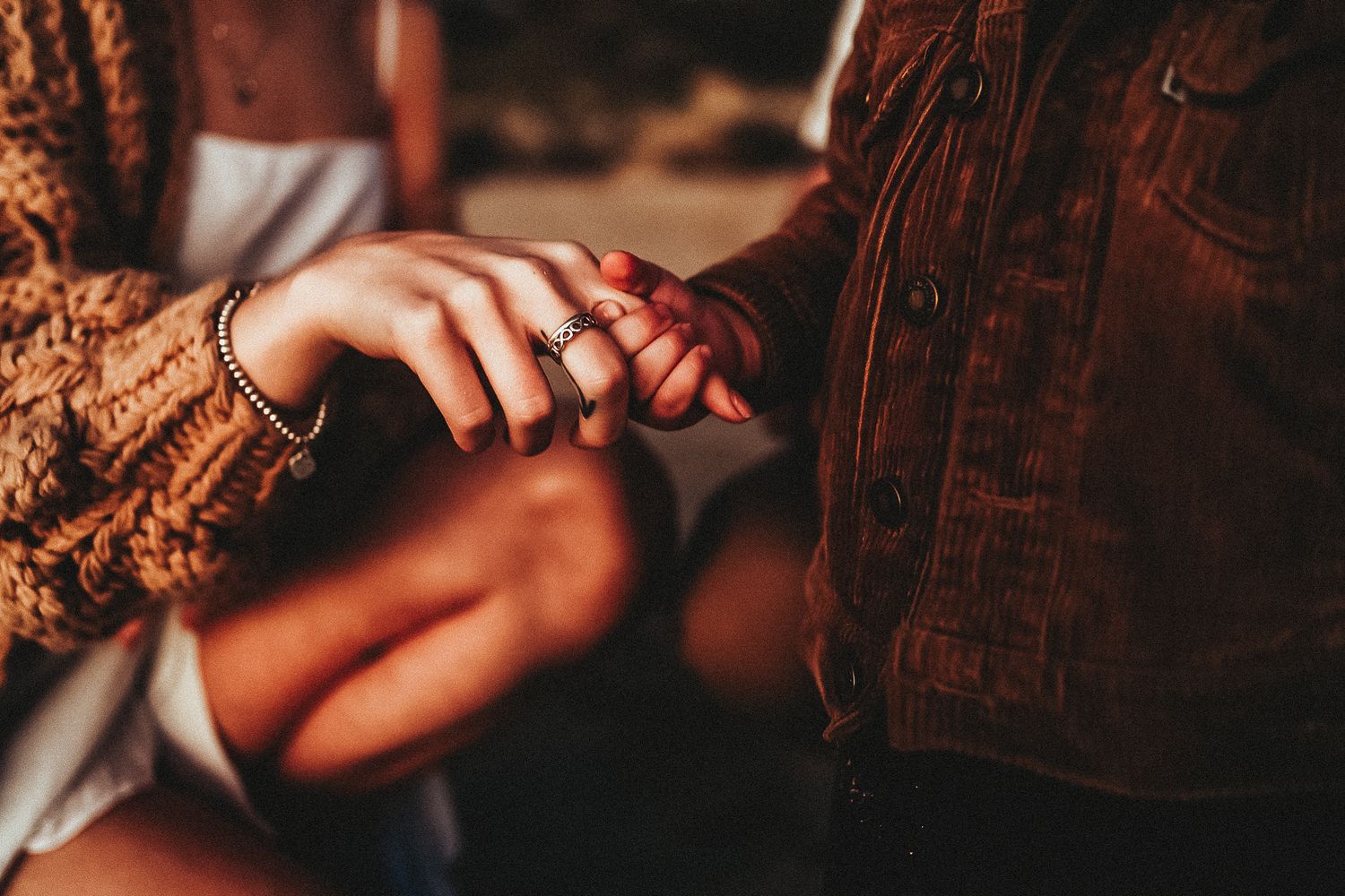 A boy holding tightly to his mothers finger