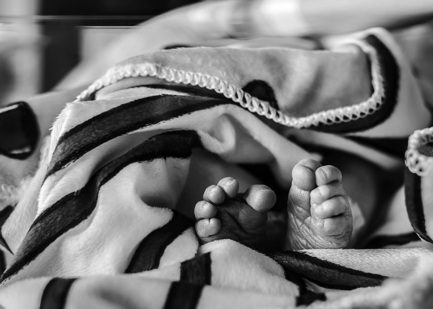 Newborn's toes sticking out of his blanket.