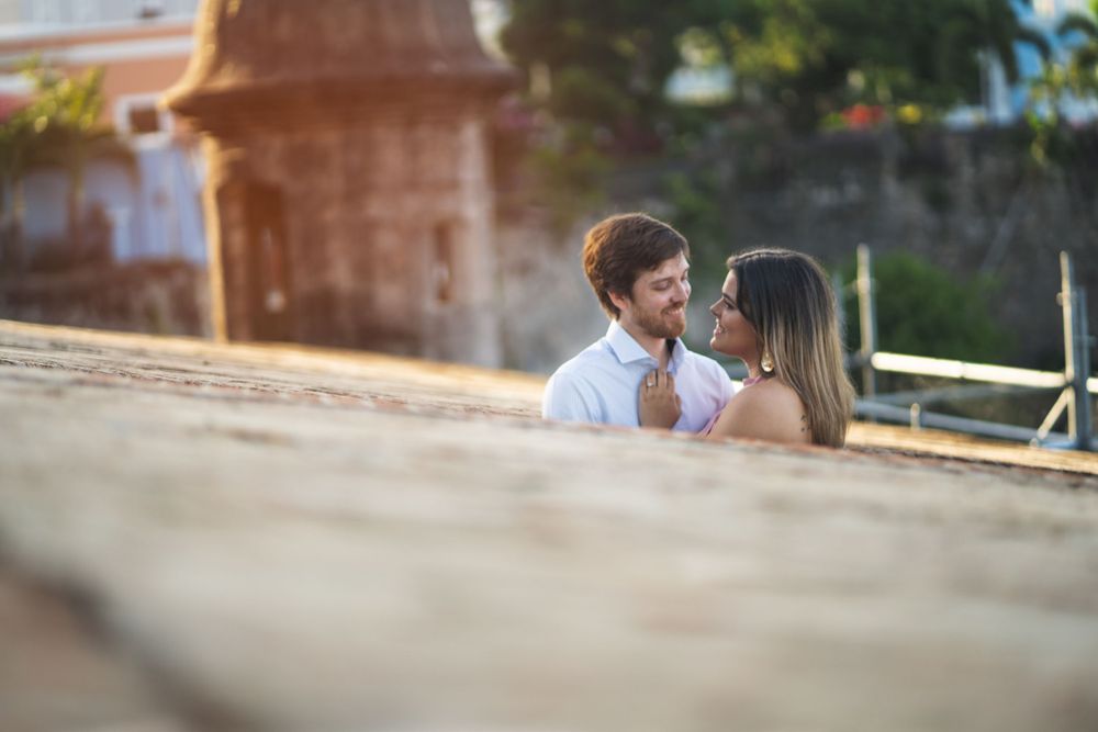 A romantic couple shares an intimate moment on a sunlit street.