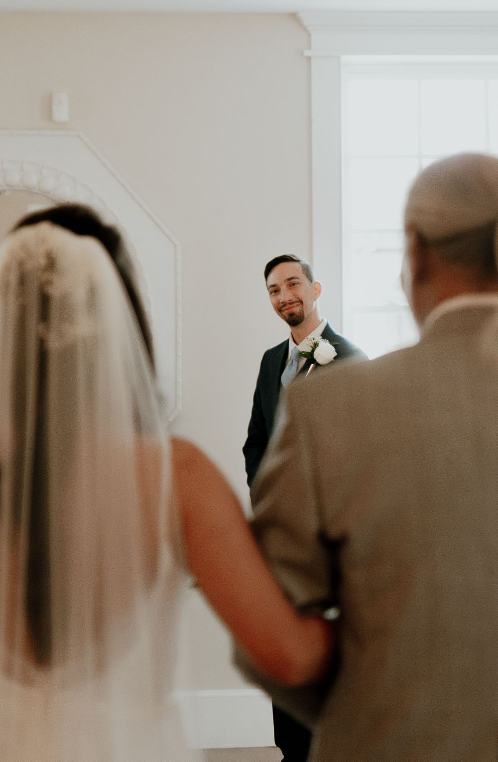 Emotional first look moment between wedding couple in natural light.
