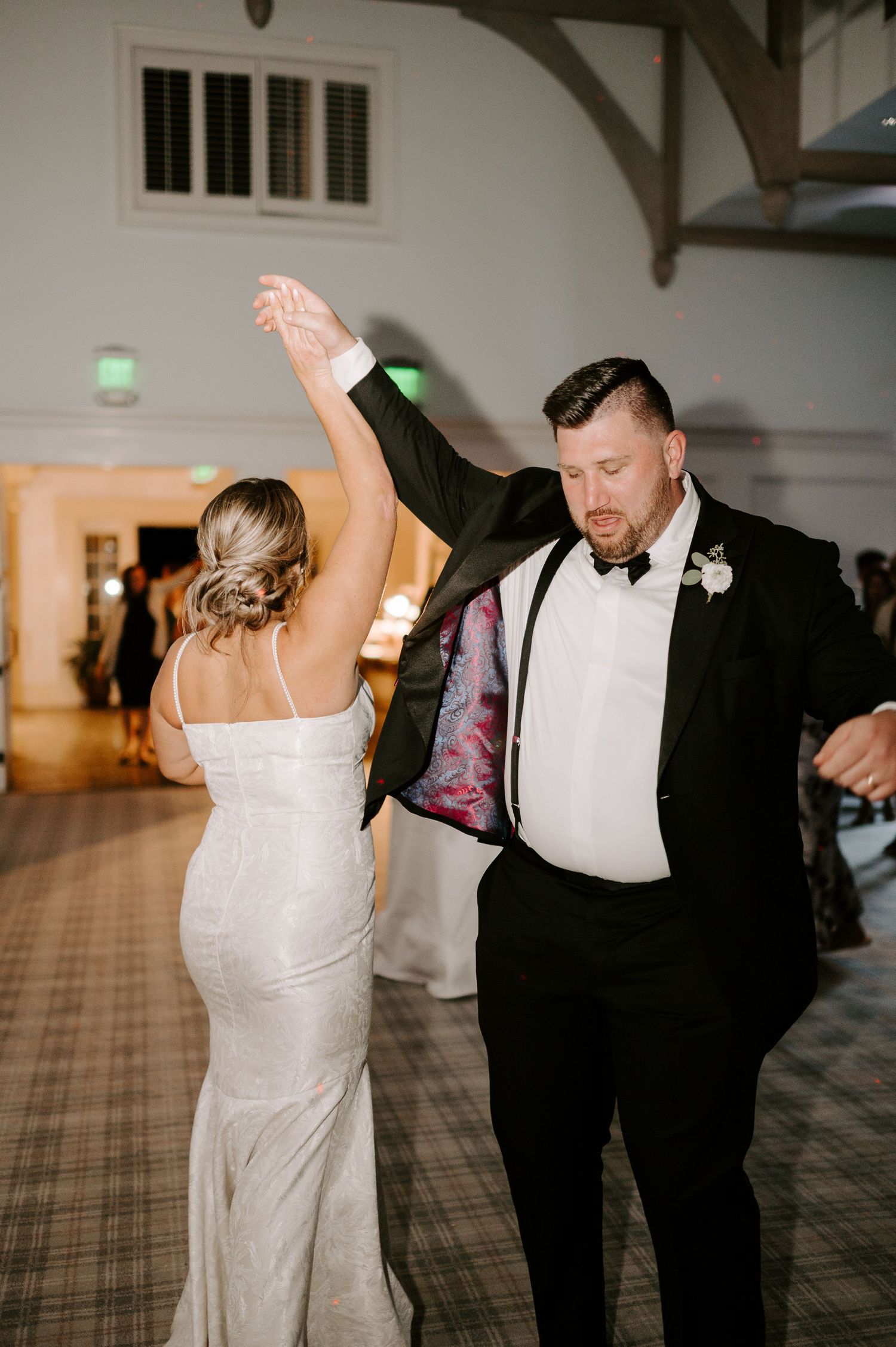 Couple dancing together on a patterned carpet floor at their wedding reception.