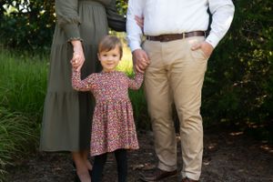 Casual outdoor family photo session with natural garden backdrop.