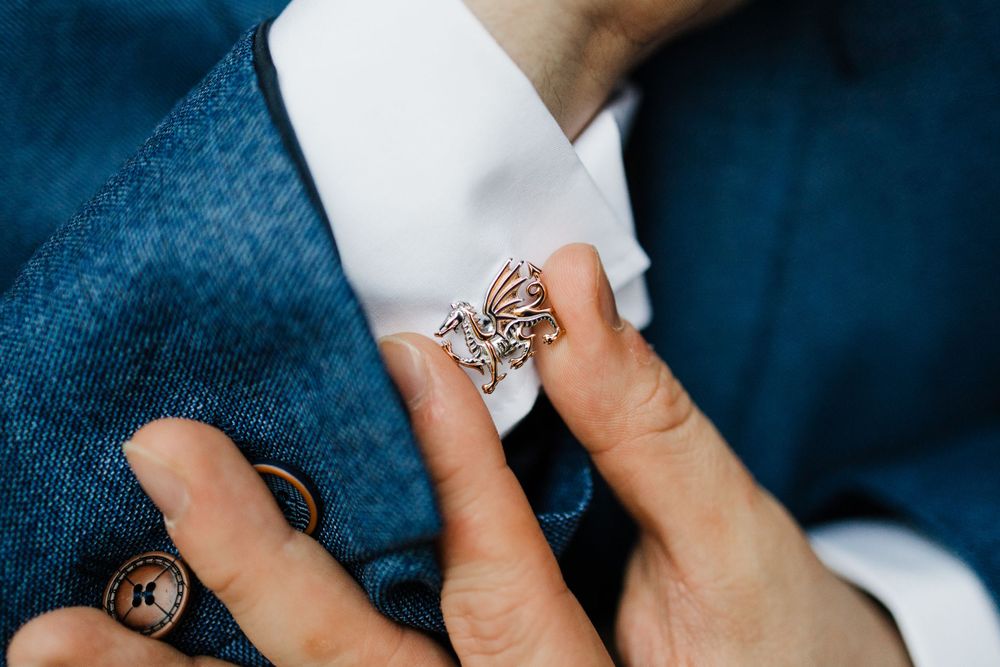 Close-up of ornate engagement ring against navy blue fabric.