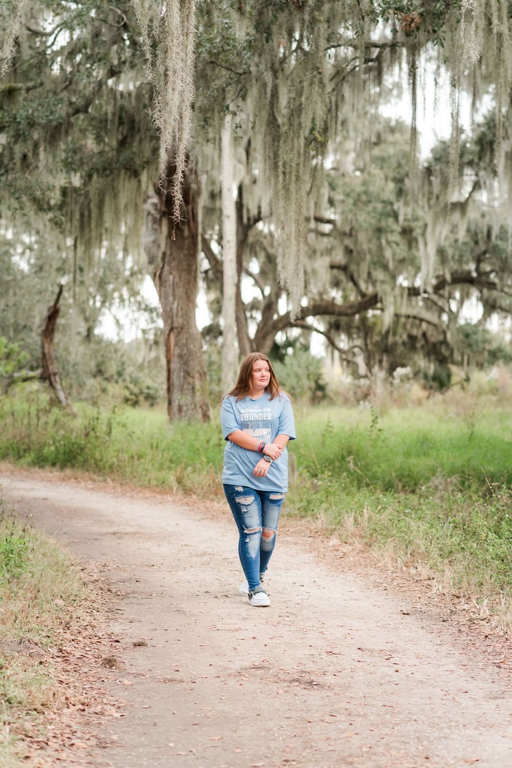 senior girl walks along dirt path at Circle B Bar Reserve Lakeland, Florida