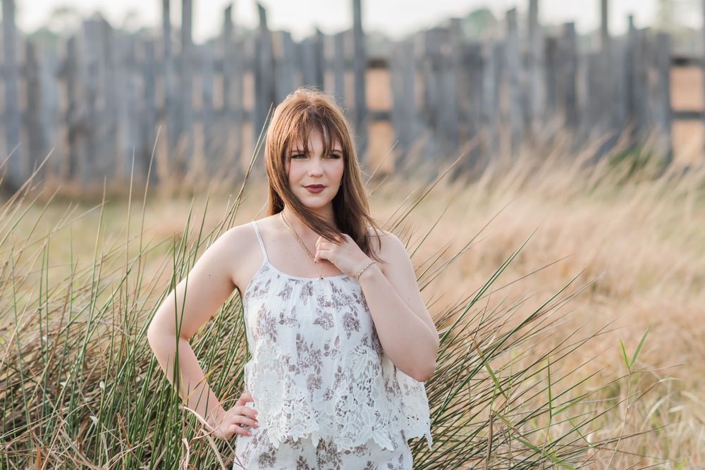 senior girl standing in grassy field Polk City, Florida The Barn on Heartland Farm